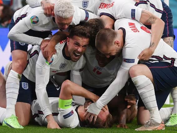 England's forward Harry Kane (bottom) celebrates with teammates after scoring a goal during the UEFA EURO 2020 semi-final football match between England and Denmark