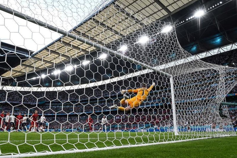 Denmark's forward Mikkel Damsgaard shoots and scores his team's first goal past England's goalkeeper Jordan Pickford
