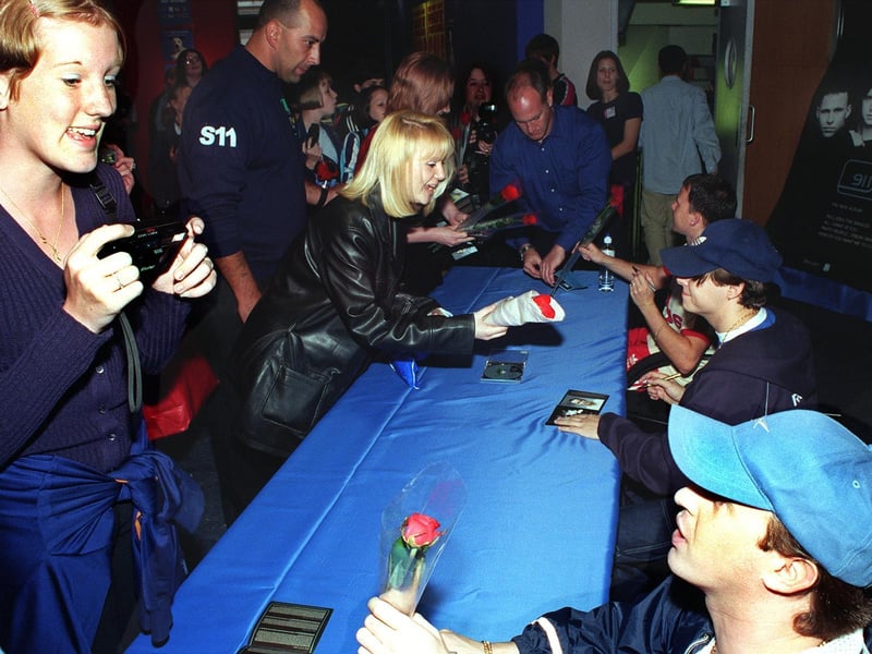 911 fans hand over presents to the band during a meet and greet at HMV.