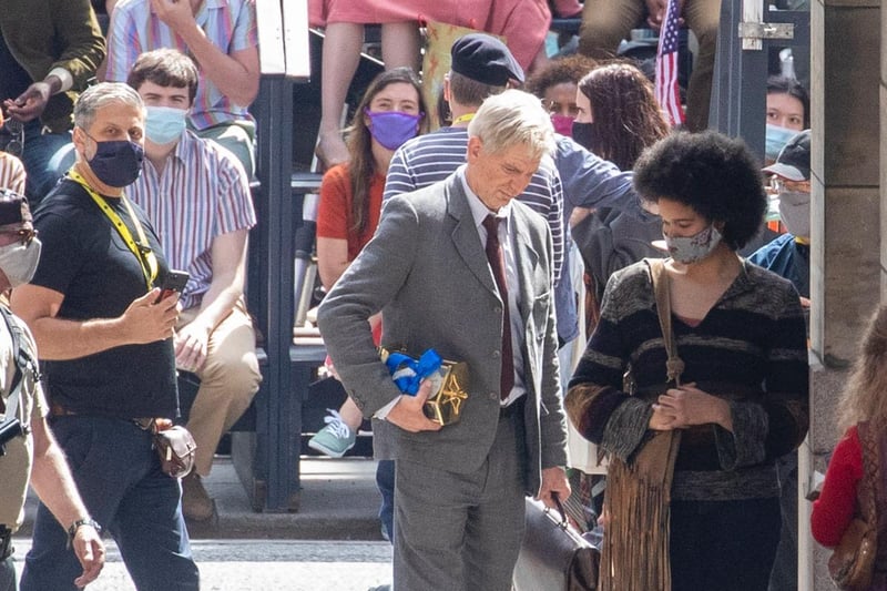 Harrison Ford's double seen carrying a carriage clock with blue ribbon.