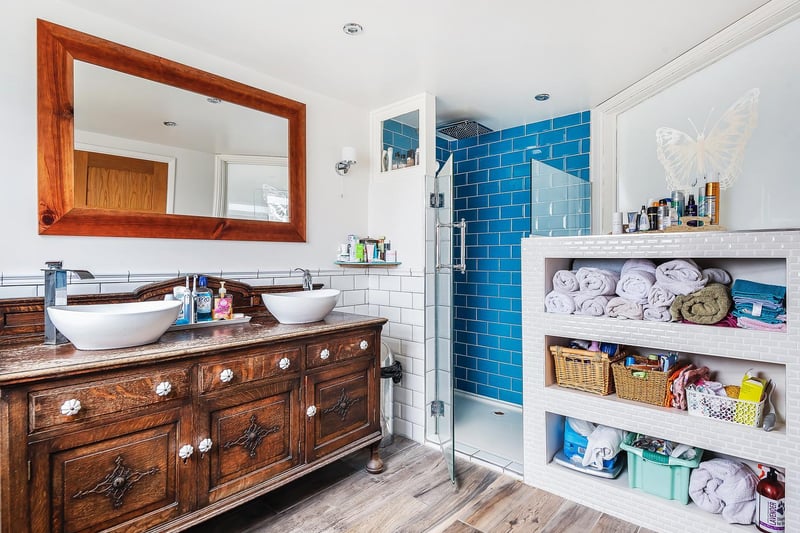 The en-suite is beautifully designed with built in tiled storage, walk in shower and double sink.