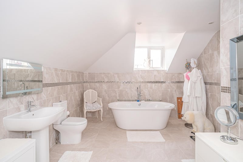 A white suite within this tiled bathroom