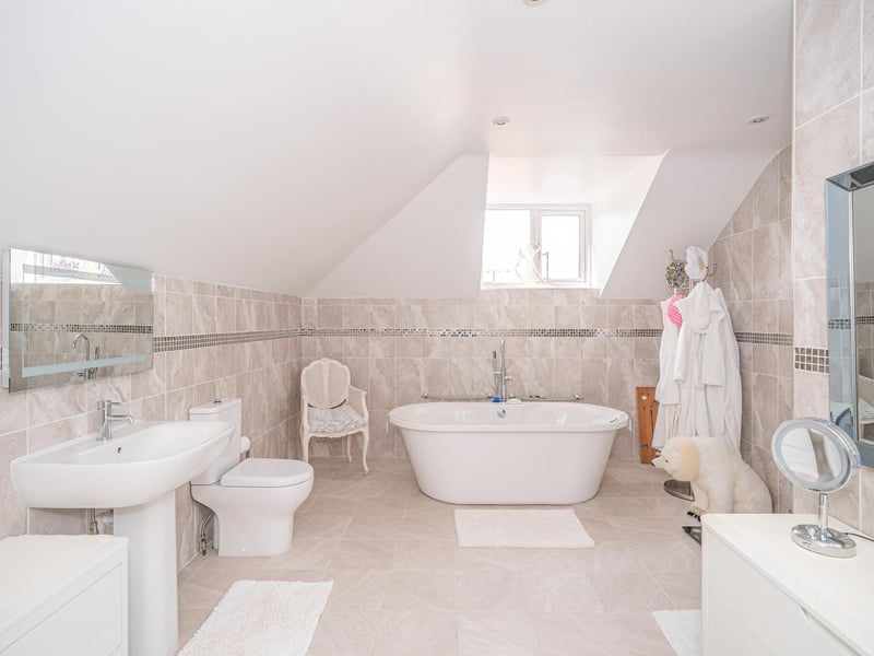 A white suite within this tiled bathroom
