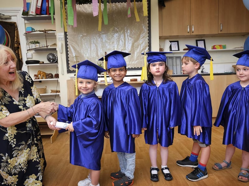 Manager Carol Morley presents the children with their graduation scrolls