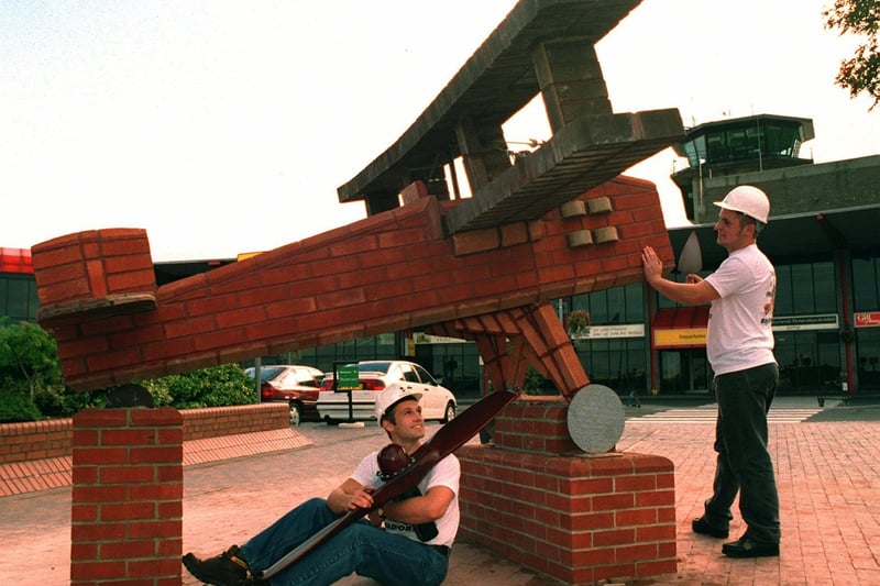 Bricklayers Paul McKay (left) and Damien Laws put the finishing touches to their brick built biplane which went on display outside Leeds Bradford Airport in September 1995.