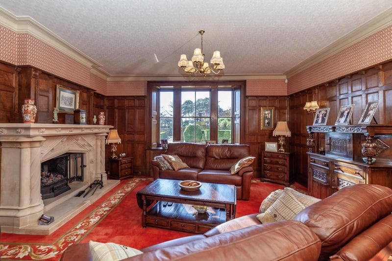 A huge fireplace and wood panelling are features within this reception room