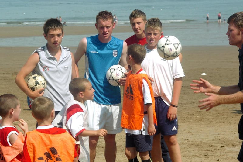 Members of the Boro Holiday Course pictured on Scarborough South Bay with Carl Cook, right, testing out the footy skills of some of the participants.