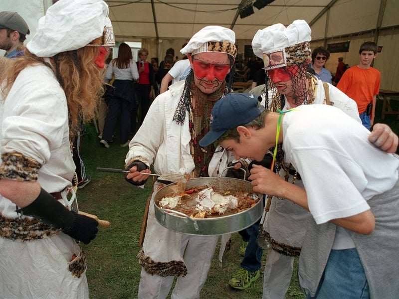 The Nomadic Chefs try to tempt a reveller into a taste of their dish.