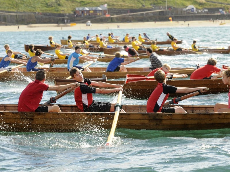 The three rowing clubs at Whitby Regatta - Fisherlads (blue), Friendship (red) and Scarborough (yellow) - content this race out at sea.