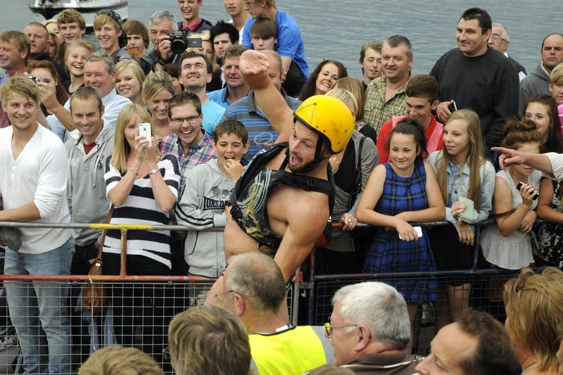 Crowds enjoying the greasy pole competition.