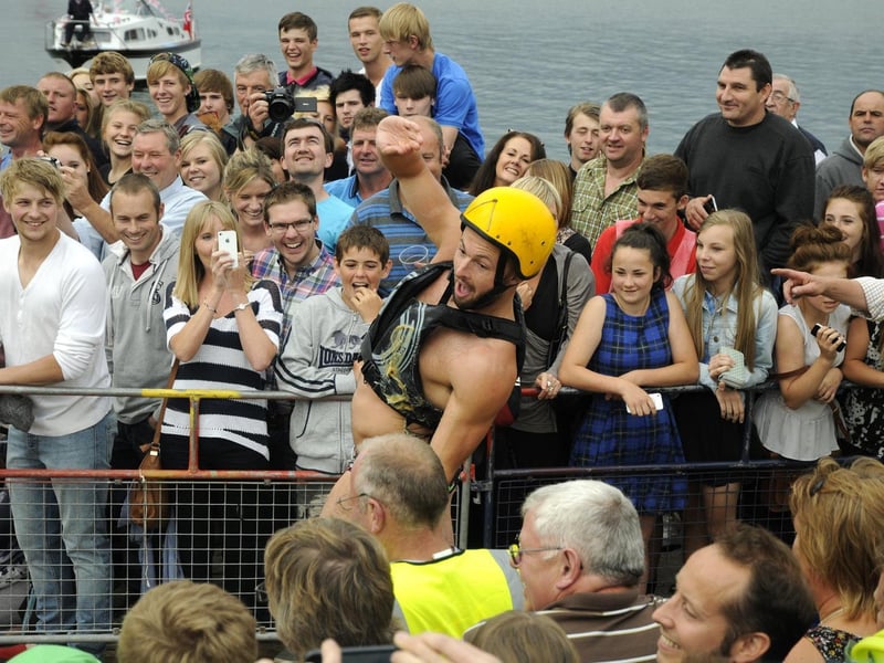 Crowds enjoying the greasy pole competition.