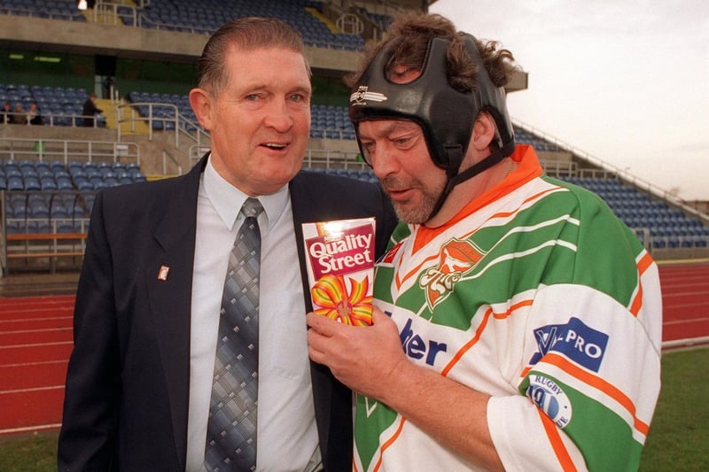 TV prankster Jeremy Beadle hands a surprise package to junior rugby league coach Colin Cooper at South Leeds Stadium in November 1996.