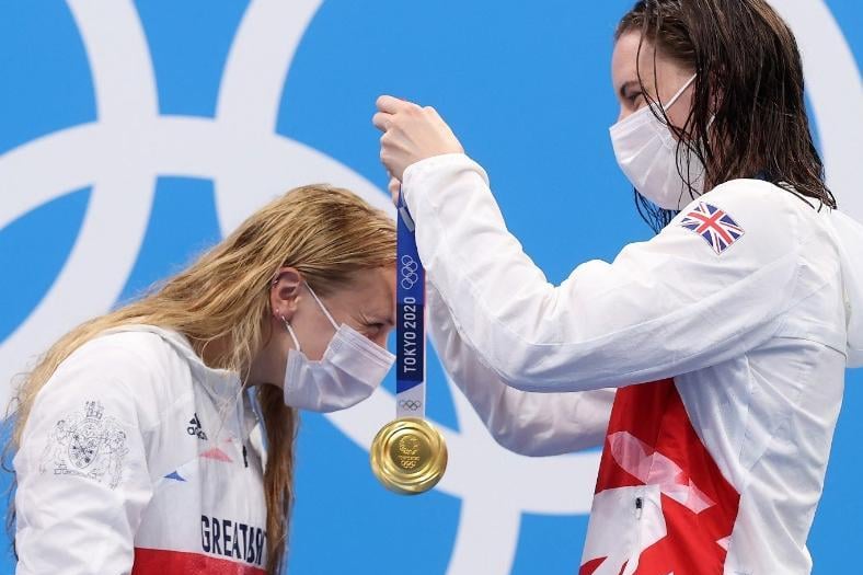 Gold medalist Kathleen Dawson of Team Great Britain (right) places the medal of Anna Hopkin of Team Great Britain around her neck during the medal ceremony