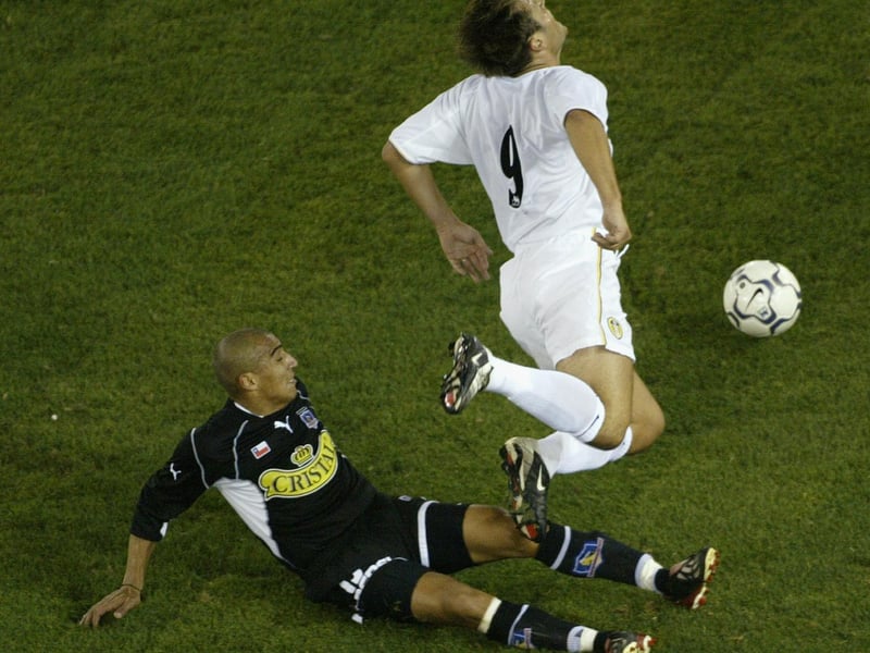 Striker Mark Viduka is brought down by Colo Colo's Joel Reyes.