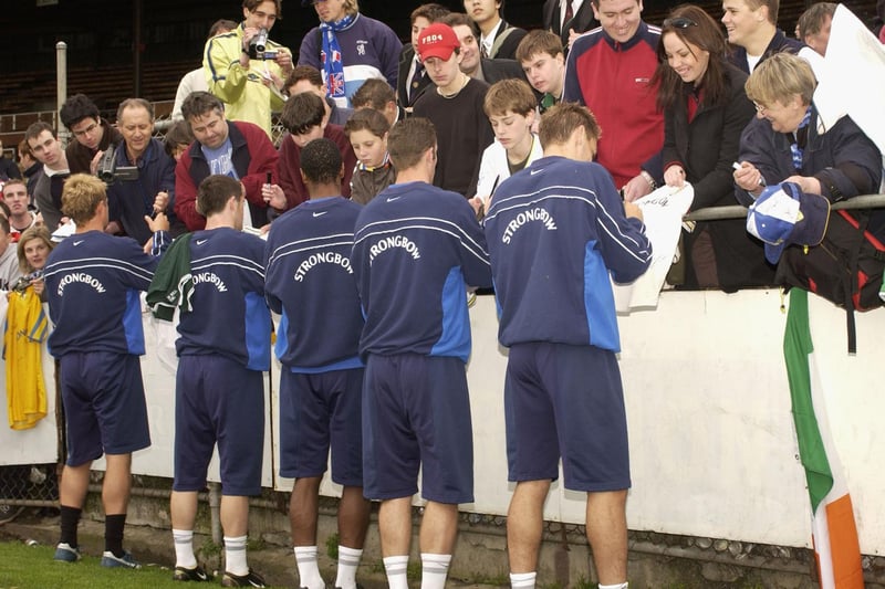 The squad sign autographs for the fans during training session.