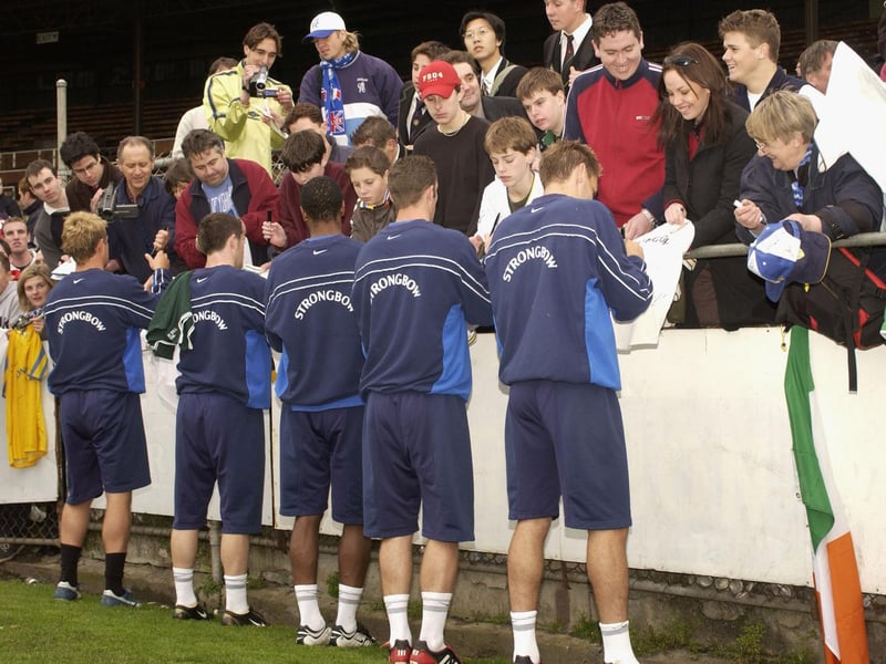 The squad sign autographs for the fans during training session.