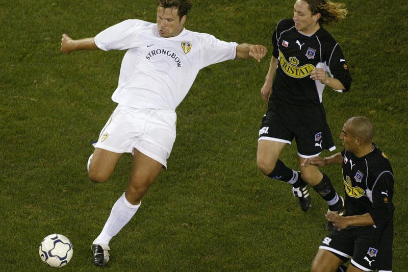 Striker Mark Viduka pulls the trigger after moving past Colo Colo's Louis Mena.