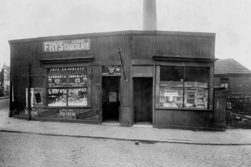 Retail premises on Botany Bay Place at the junction of Canal Road in Armley in April 1923. On the right is Charles Coakley, hairdresser, and on the left is Moran Valentine confectioners.
