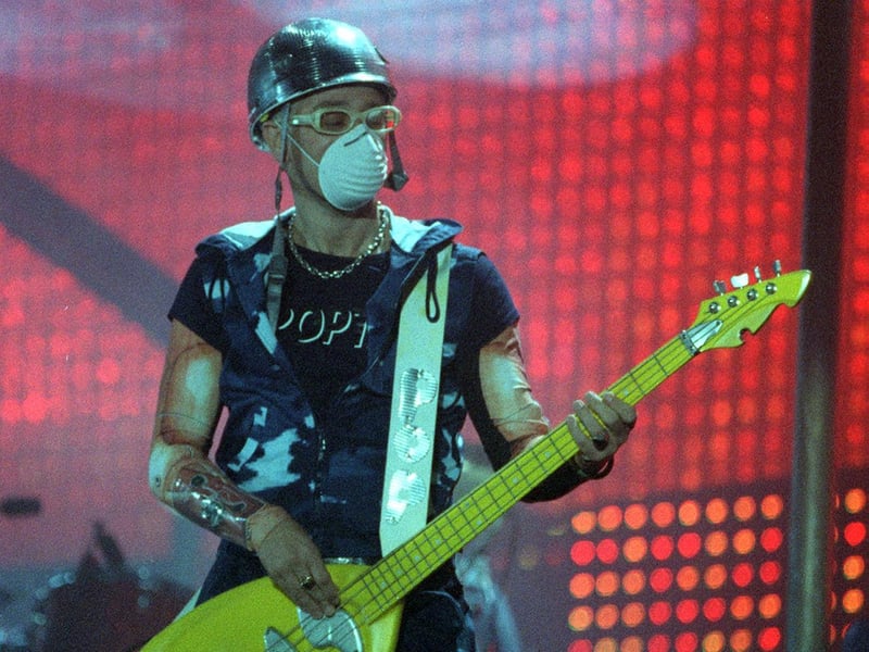 u2 guitarist Adam Clayton performs on stage.