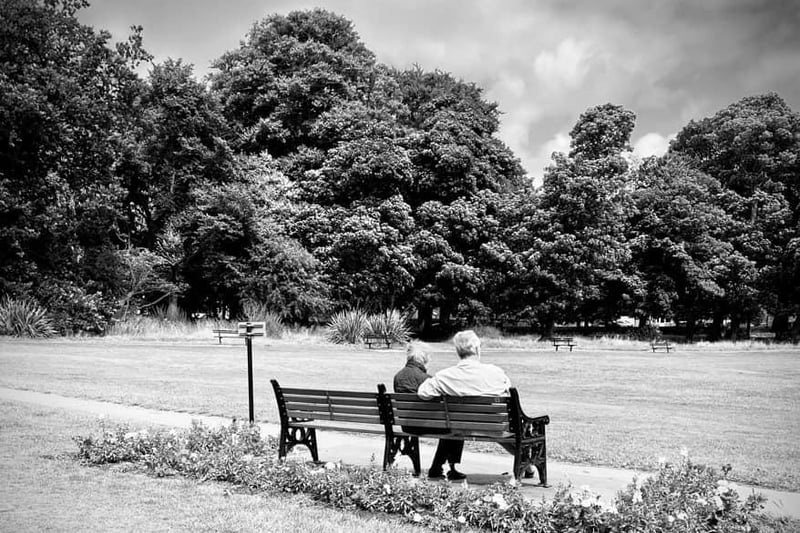 A couple sit on a bench in Horsforth Park.