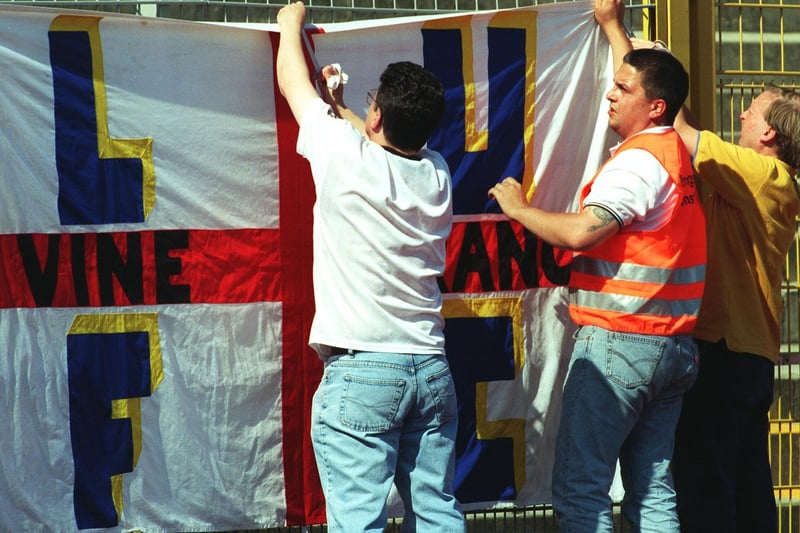 Members from the Vine branch of the Leeds United supporters club attach their banner to the fencing before the friendly against  VFL Wolfsburg in Germany.