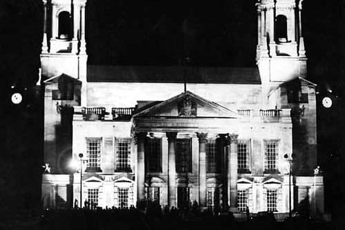 A view of Leeds Civic Hall taken around 10.45pm on the evening of the VJ celebrations. People can be seen silhouetted against the white portland stone floodlit building.
