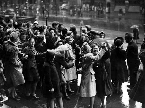 Jubilant Leeds people dancing in front of Leeds Town Hall.