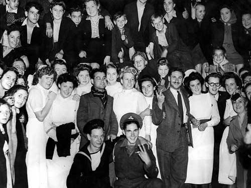 This photograph was taken at 1.30am, when celebrations continued into the early hours. The group includes nurses, servicemen and children.