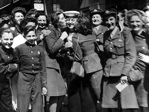 Outside the NAAFI Club on Albion Street, scene of jubilation on VJ Day. The sailor in the middle is being kissed by two WAAFS.