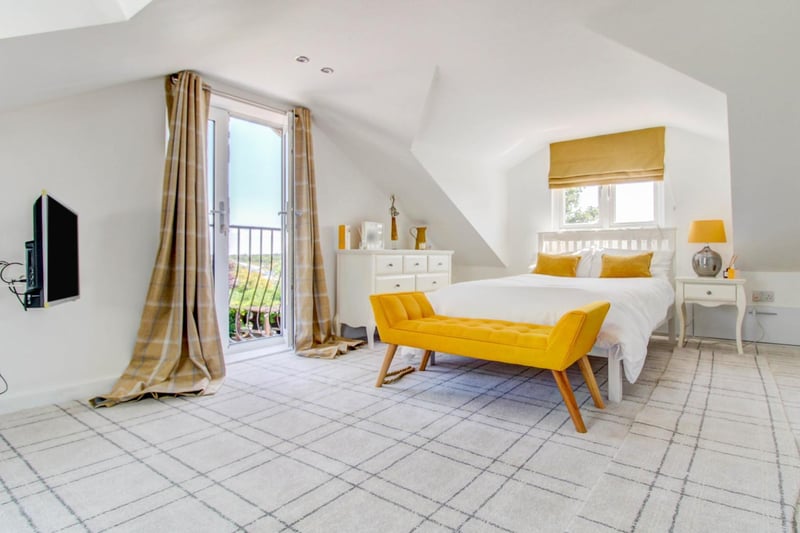 The master bedroom is equipped with stunning views of the garden, bright natural light and a TV.