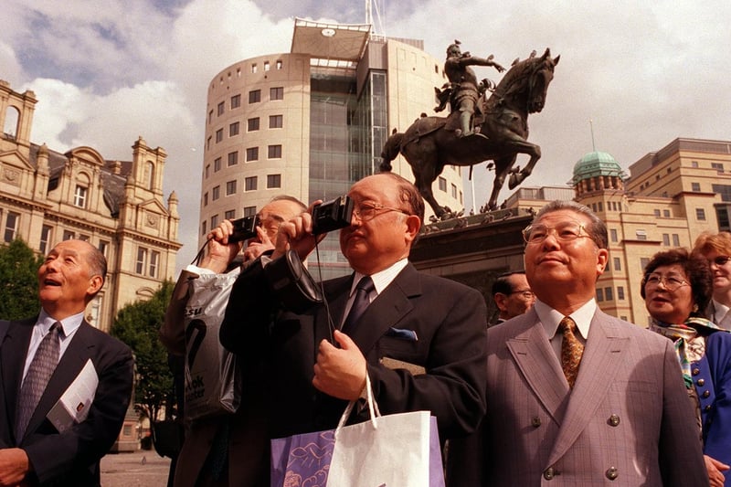 Japanese businessmen are pictured snapping away in City Square during a visit to Leeds to find out the secret of its success.