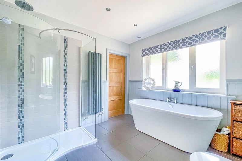 A deep bath and a walk-in shower feature within this bathroom