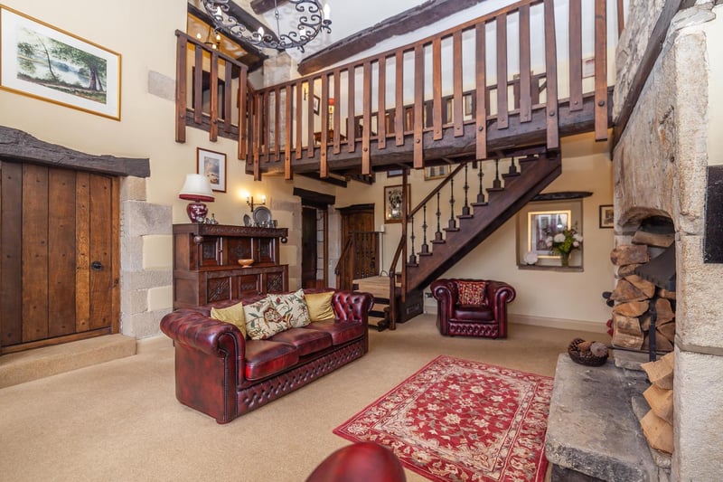 A huge stone fireplace and the stairs and gallery dominate this space