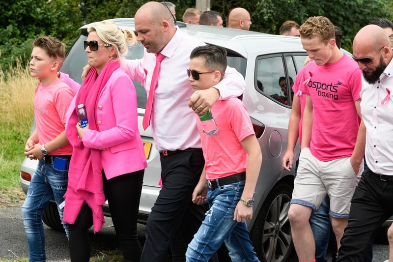 Mourners wear pink to pay their respects.