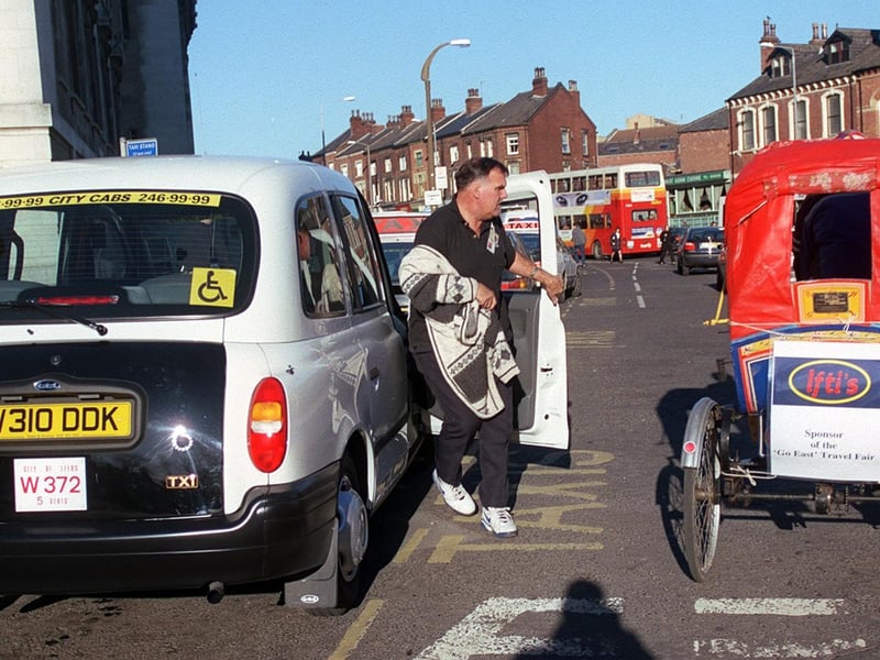 A Leeds taxi driver checks out the competition as Mick Thomas rides by on his rickshaw as part of the Asian Fair at the University of Leeds.