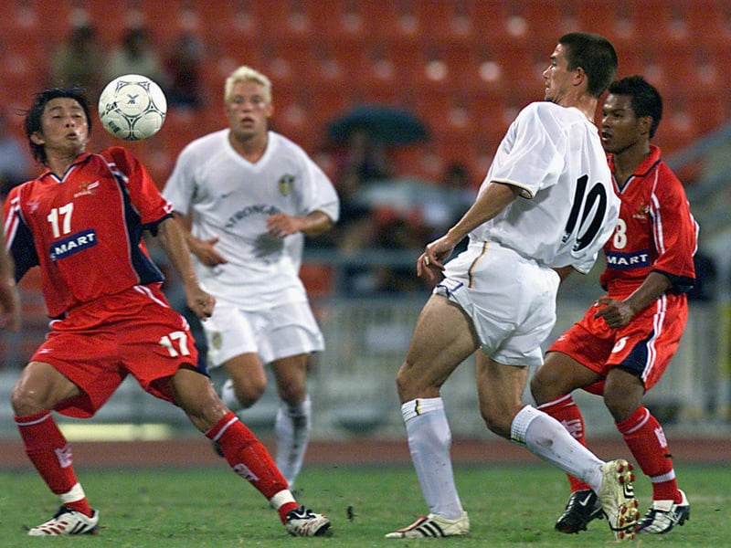 Harry Kewell battles for the ball with D. Chalermsan.