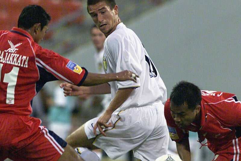 Harry Kewell is checked by T. Pajkkata and N. Vachiraban.