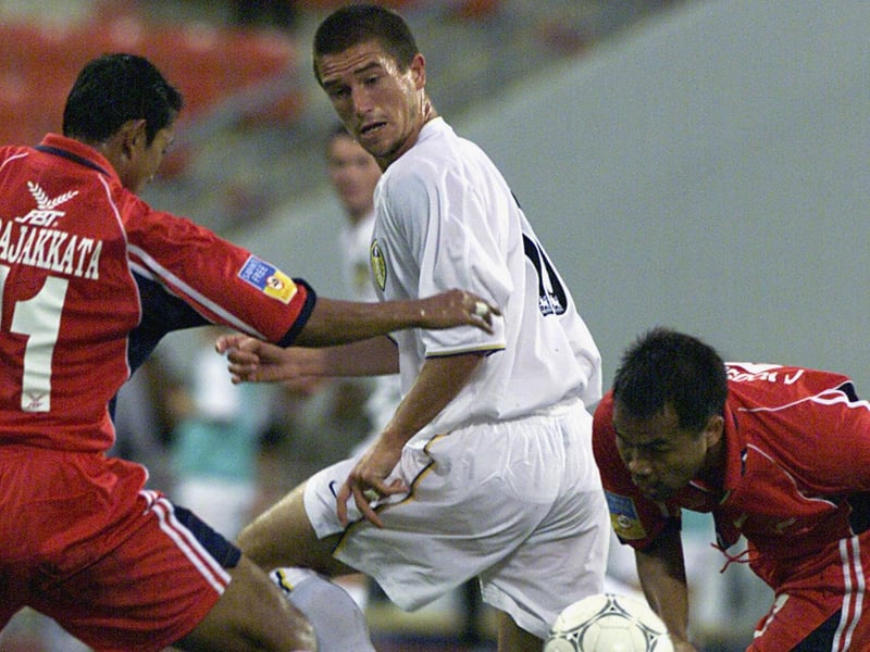 Harry Kewell is checked by T. Pajkkata and N. Vachiraban.