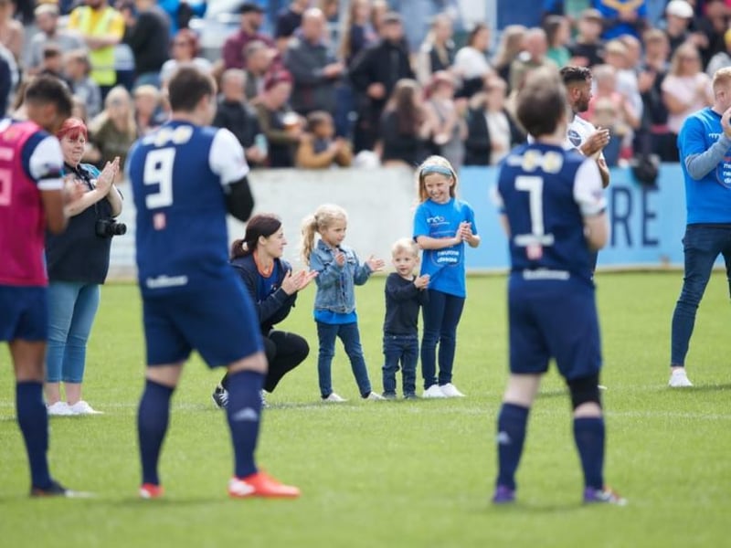 Taking to the pitch to applause from players and supporters.