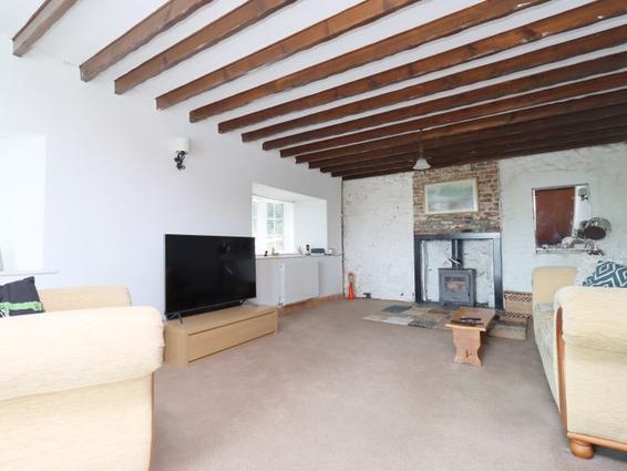 The lounge has a feature fireplace with woodburning stove