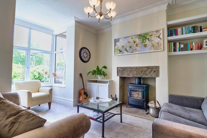The living room lounge area is a stunning space filled with natural light provided by the bay window. It has an Inglenook style fireplace with its cast iron burner being the focal point of the room, and also has alcoves with fitted shelving.
