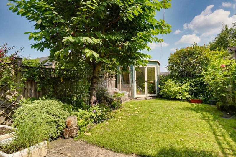 At the front there is a low maintenance garden area and on street parking. At the rear, is a good sized garden with a summerhouse, lawn, edible cherry tree and mature planted borders.