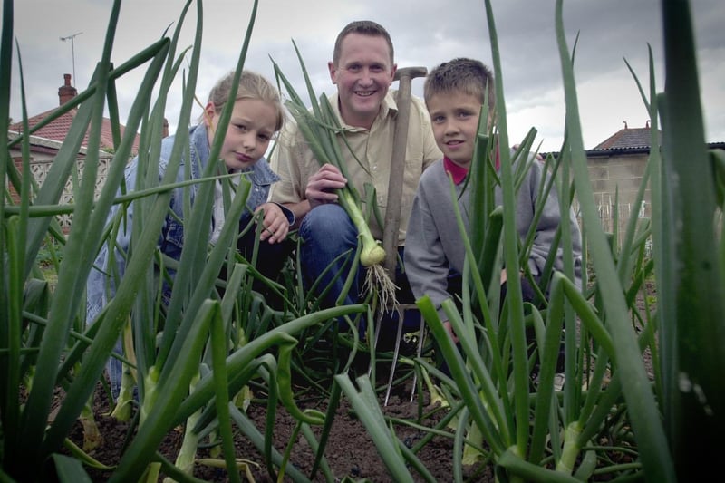 Pupils from Raynville Primary School visited Armley Ridge Road Allotments in June 2002. Pictured, left to right, are Nathasha Lazar, allotments secretary Mark Jackson and Matthew Davison. Photo: Tony Johnson