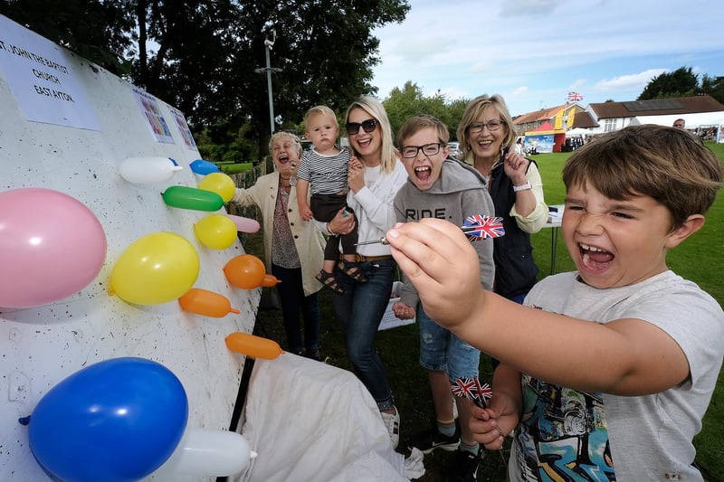 Theo McMann is cheered on as he aims to win at the balloon challenge stall.