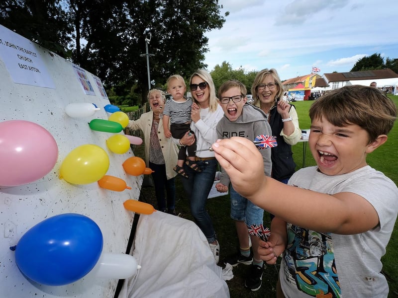 Theo McMann is cheered on as he aims to win at the balloon challenge stall.