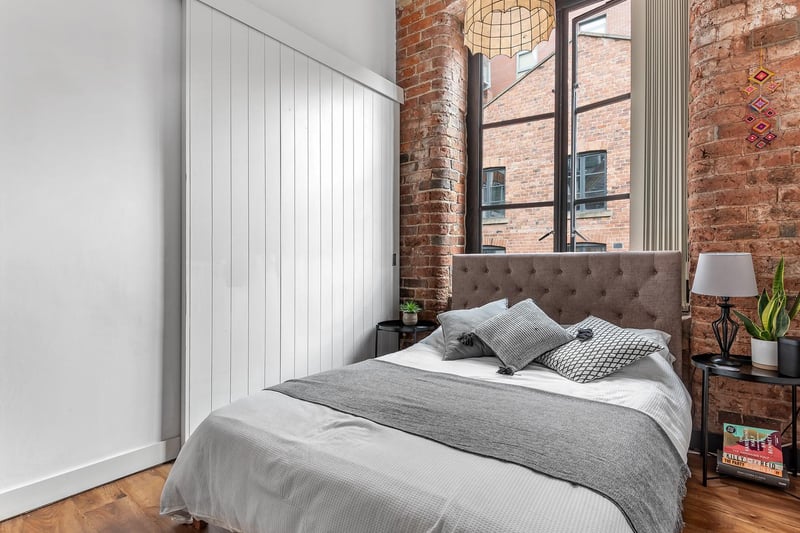 There are two bedrooms in the property. The first one is a carpeted double bedroom with exposed brick, high ceilings and the feature wooden beams. A feature sliding door leads out into the living area.