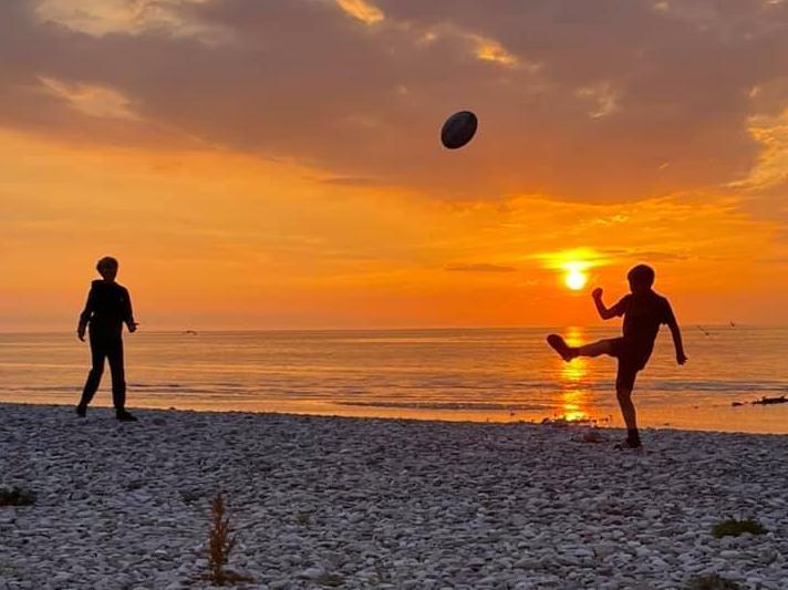 Trisha Gaskell - watching the sunset on holiday, while the boys practice rugby.