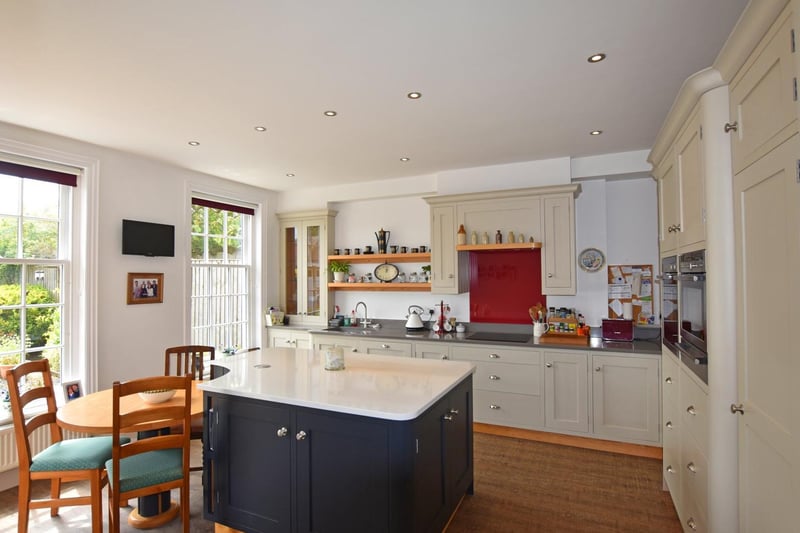 A central workstation and slot-in dining table feature in the centre of this kitchen, with its large windows.