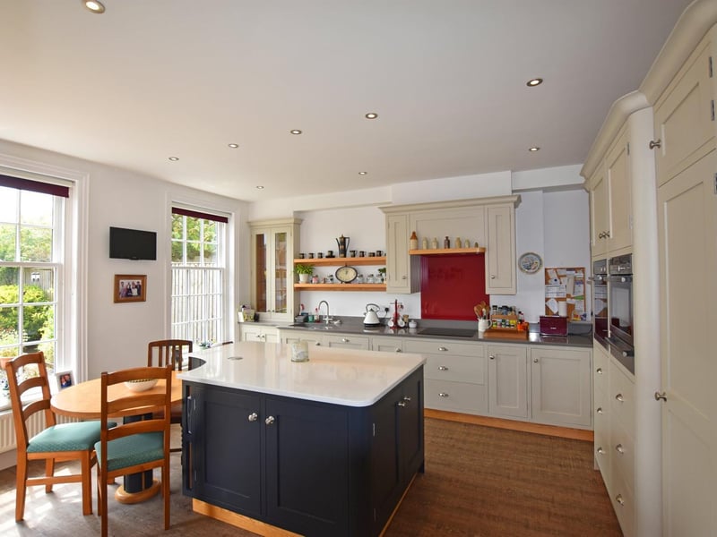 A central workstation and slot-in dining table feature in the centre of this kitchen, with its large windows.