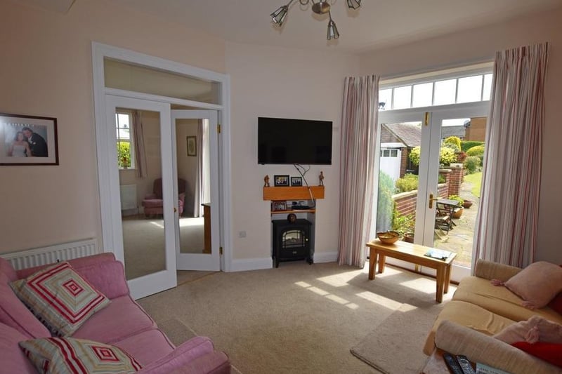 A sitting room, with patio doors leading outside.